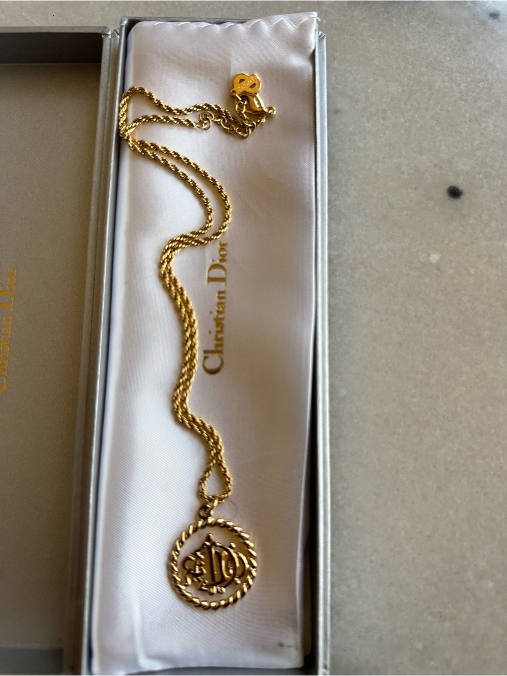 Vintage Christian Dior pendant necklace featuring a prominent logo medallion
